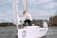 Man in White Long Sleeve Shirt and Black Pants Sitting on White Boat
