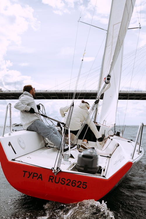 Man and Woman Riding on White and Red Boat