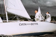 Man in White Long Sleeve Shirt and Black Pants Sitting on White Sail Boat