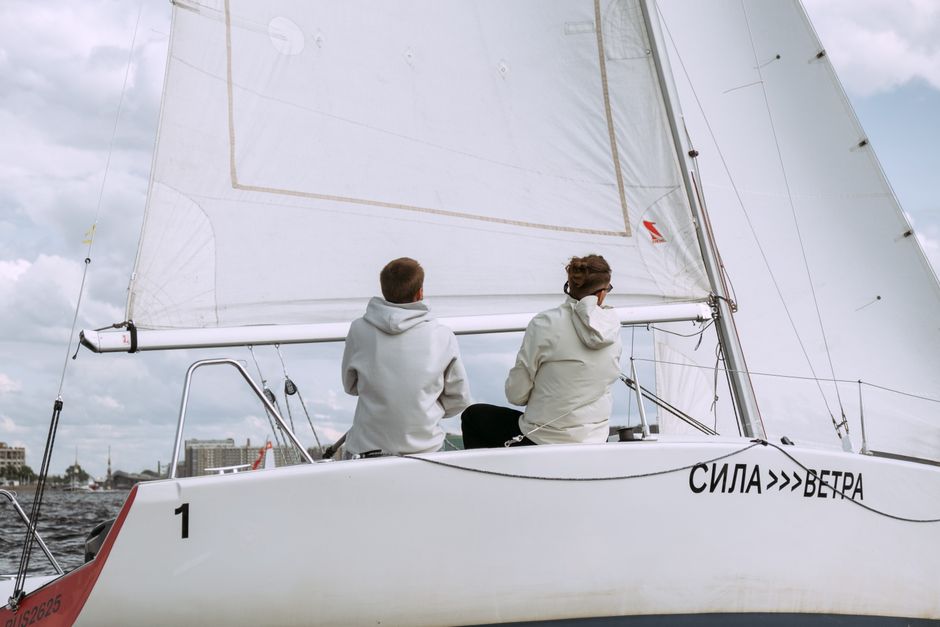 Ultimate Private Miami Captained Yacht Rental: Sunset Options Review 2026 - Two individuals sailing a yacht, enjoying a nautical adventure on a cloudy day.