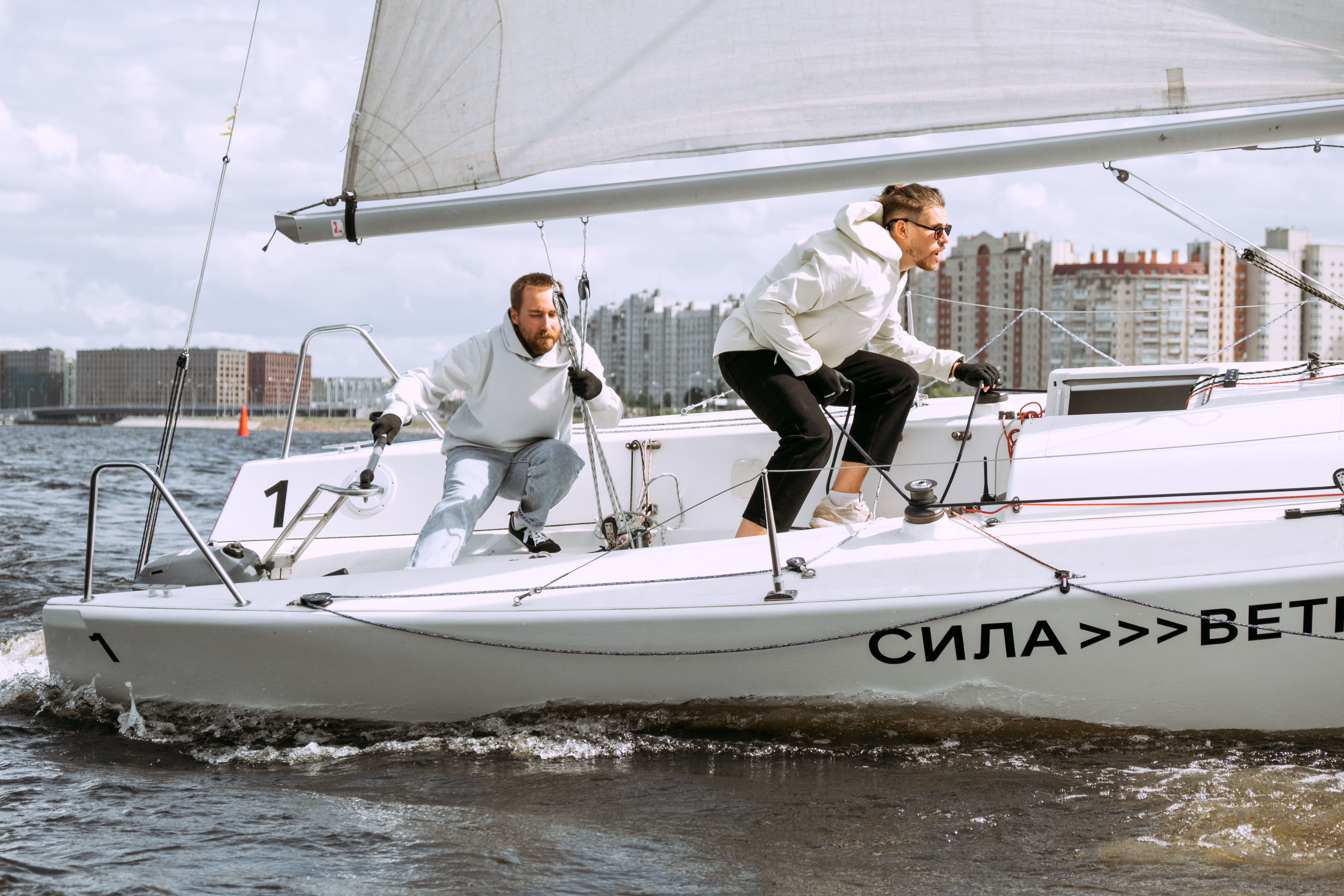 Ultimate Private Luxury Yacht |+ 2 free Jet Skis | + Sea Pool Review: The Ultimate Miami Experience Review 2026 - Two men sailing a yacht on city waters with urban skyline in background.
