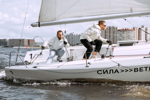 Man in White Long Sleeve Shirt and Black Pants Riding White and Black Sail Boat during