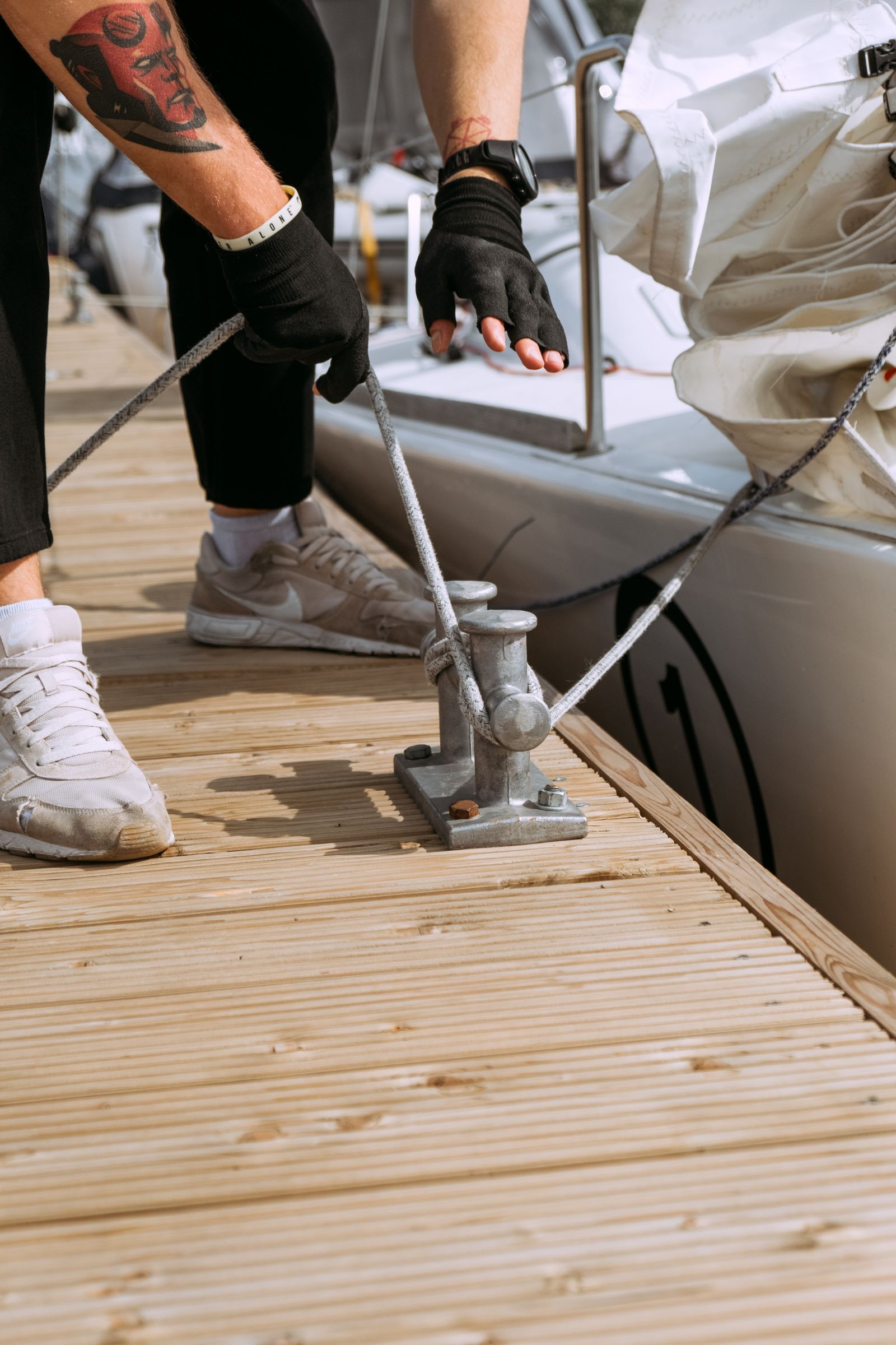 Boat tied at a wooden dock cleat on calm lake water