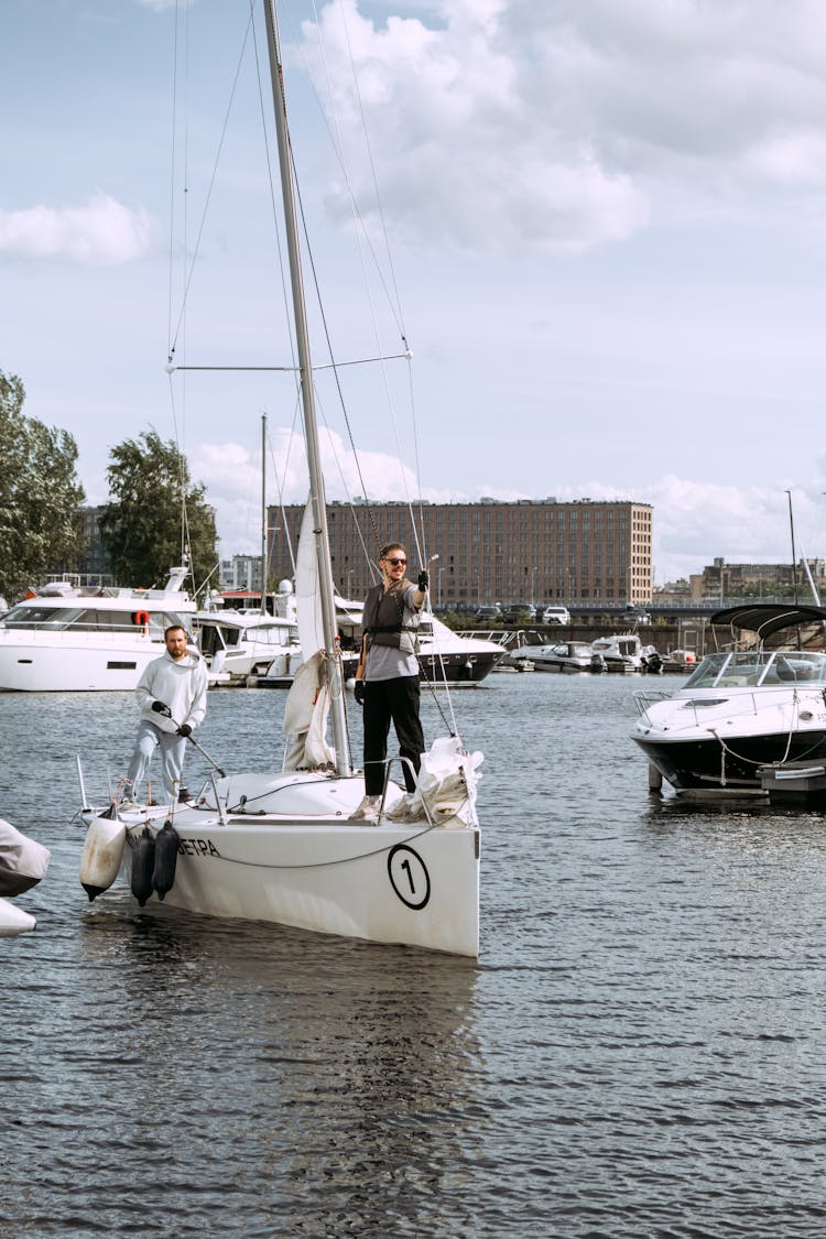 People Riding On White Sail Boat On Body Of Water