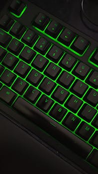 Close-up of a gaming keyboard with vibrant green backlights highlighting the keys.