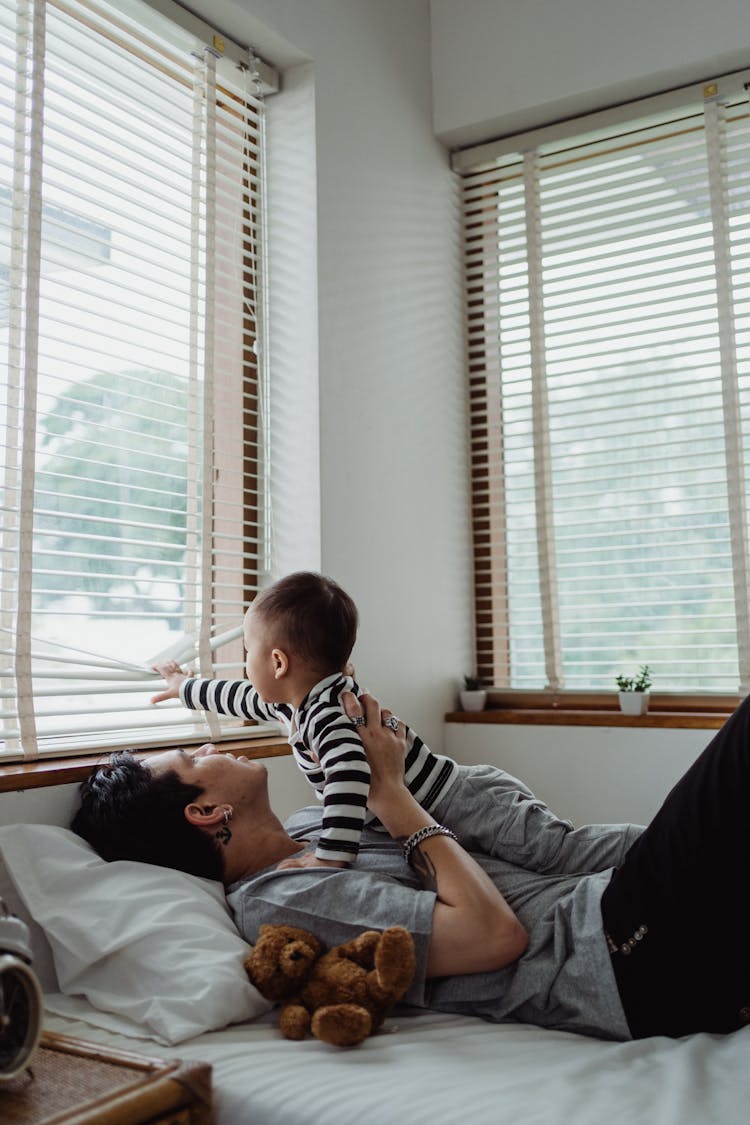 Father And Baby Son Lying On Bed