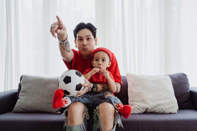 Father With Son Watching TV From Sofa