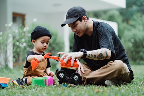 Free Father and Son Playing with Toy Cars Outdoors  Stock Photo