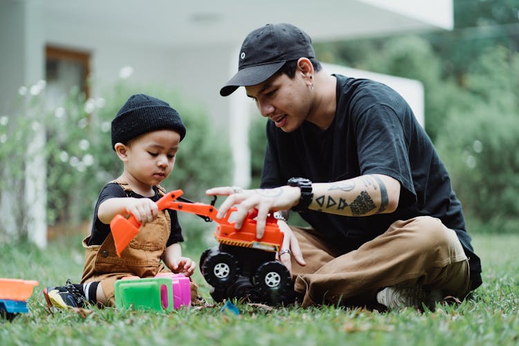 Father And Son Playing With Toy Cars Outdoors 