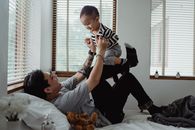 父子俩在阳光明媚的卧室里快乐地玩耍