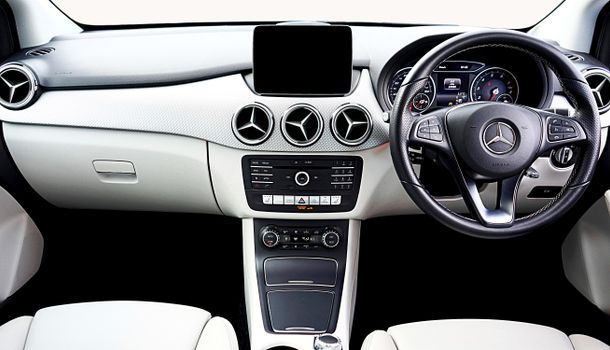 High-quality photograph of a modern Mercedes-Benz car interior showcasing the dashboard and steering wheel.
