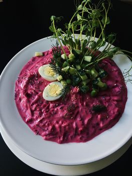 Delicious beetroot salad topped with eggs and fresh greens, perfect for summer.