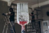 Close-up of a Dirty Paintbrush with Men Painting the Walls in the Background