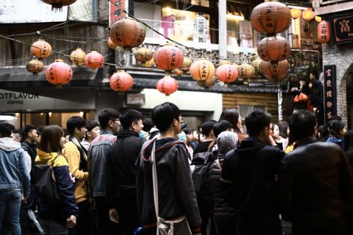 Free A bustling crowd under traditional Chinese lanterns in an urban setting. Stock Photo