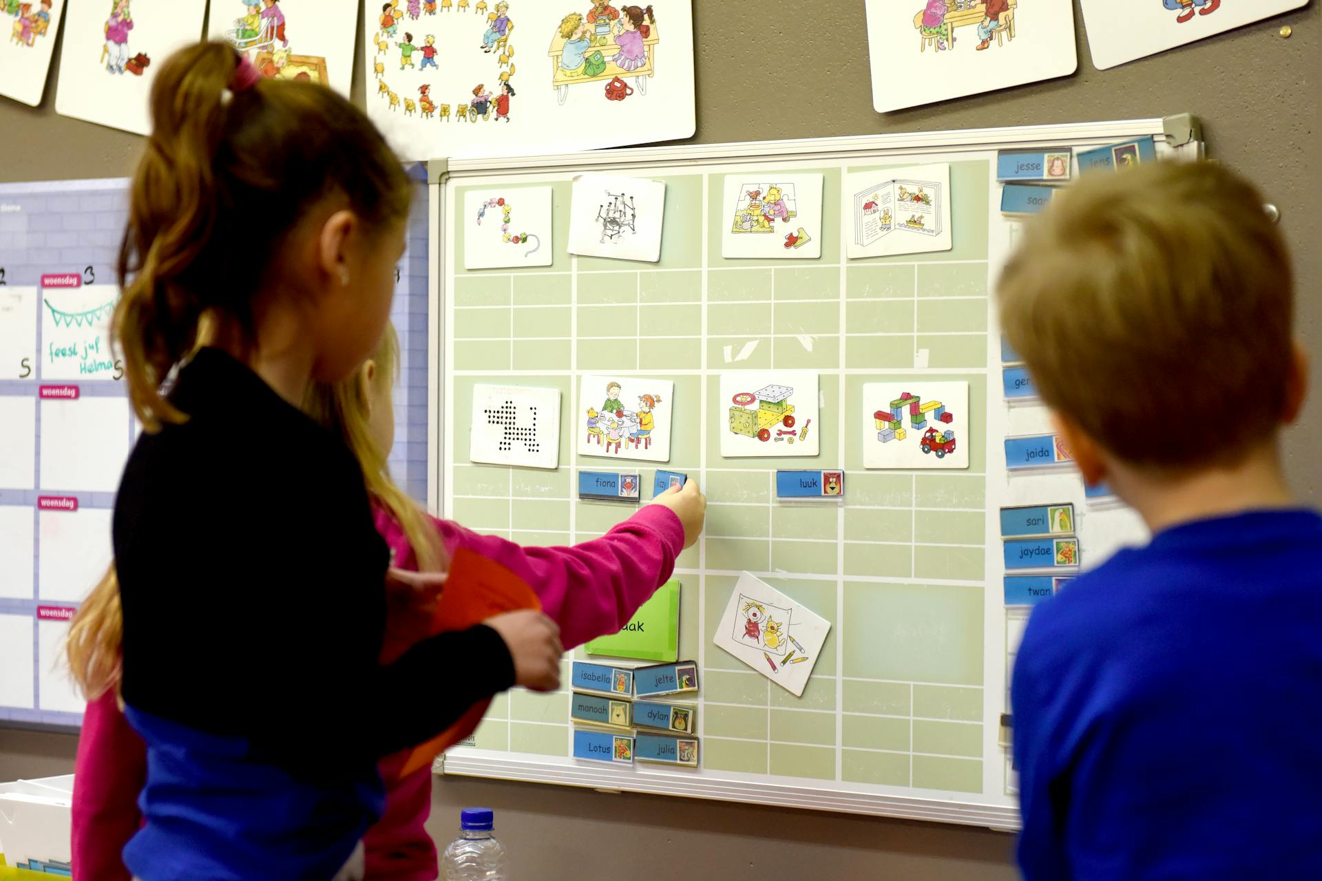 Children in a classroom interact with an educational board to enhance learning and teamwork.