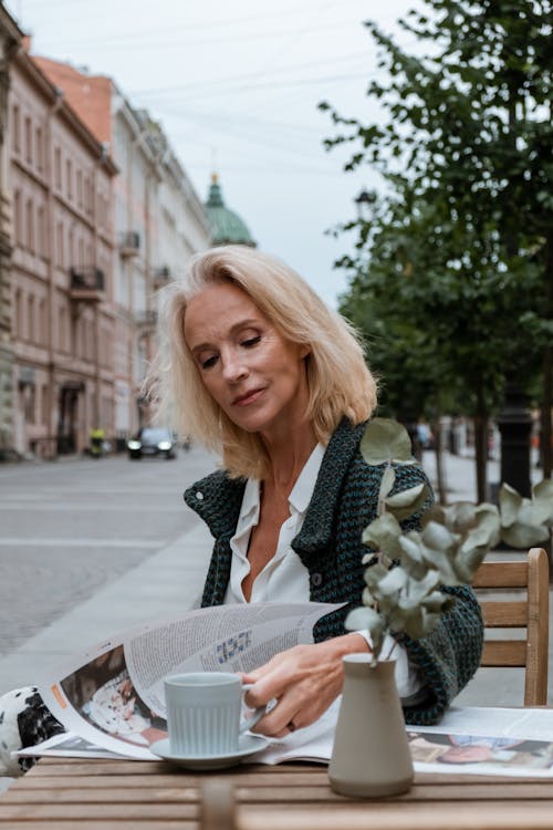 Woman in Black and White Coat Holding White Paper