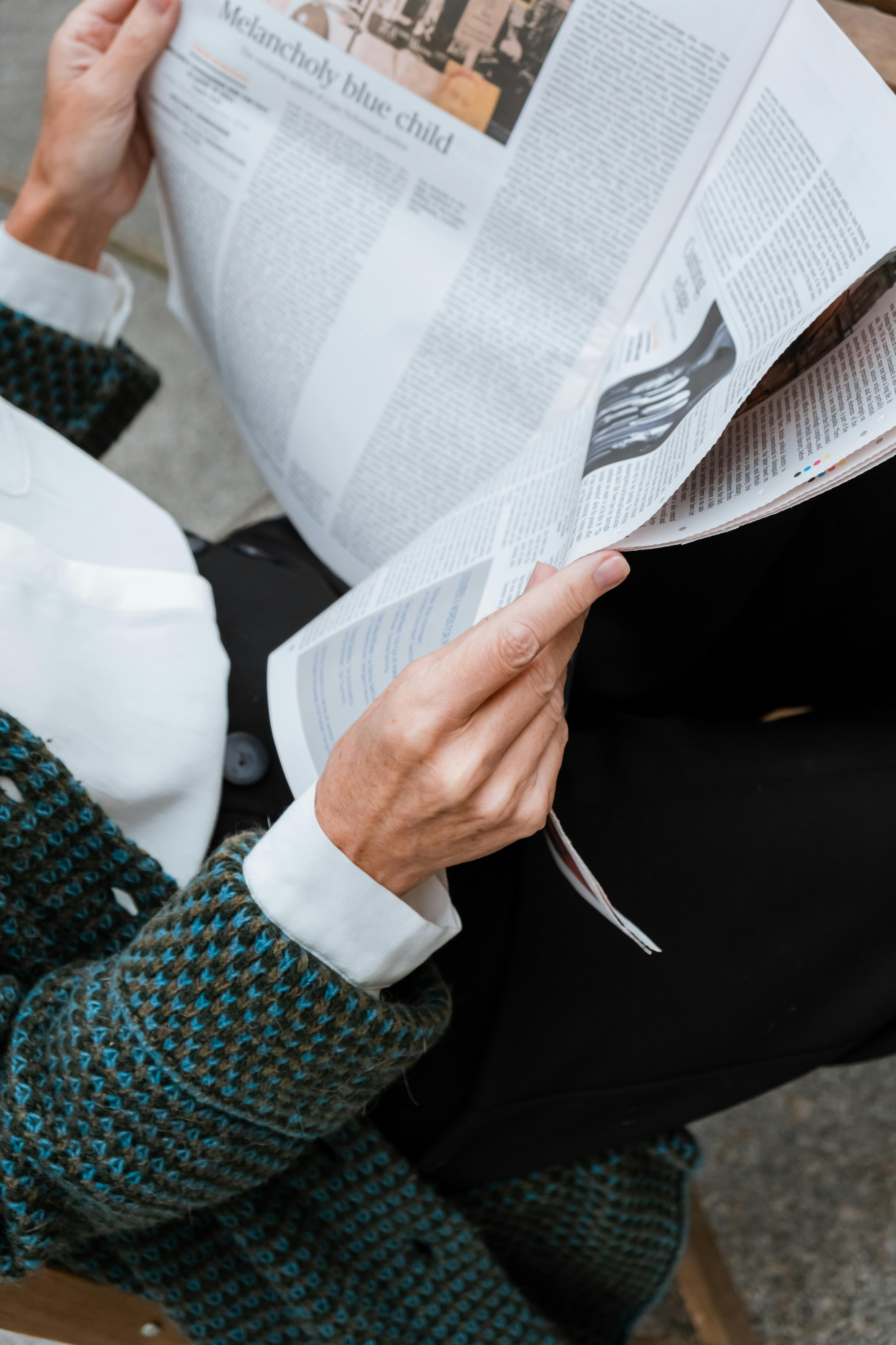 person in green and black long sleeve shirt holding white paper