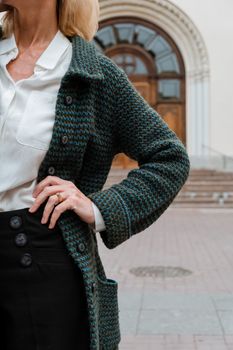 一位穿着优雅服装的时尚前卫女性，站在历史建筑的入口前