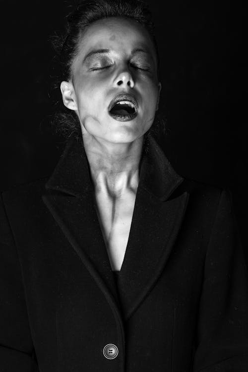 Black and White Photo of a Woman in a Coat with Mouth Open