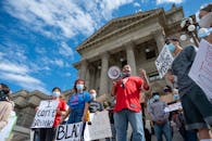 Group of unrecognizable multiethnic protesters with BLM placards and speaker