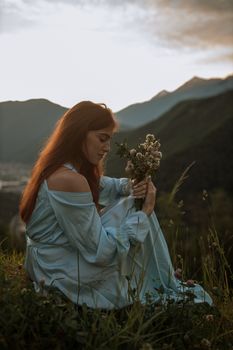 一位穿着蓝色连衣裙的女子，在开满山花的背景前，宁静地伫立着