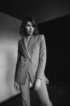 Elegant black and white portrait of a woman in a stylish suit, combining modern and classic vibes.