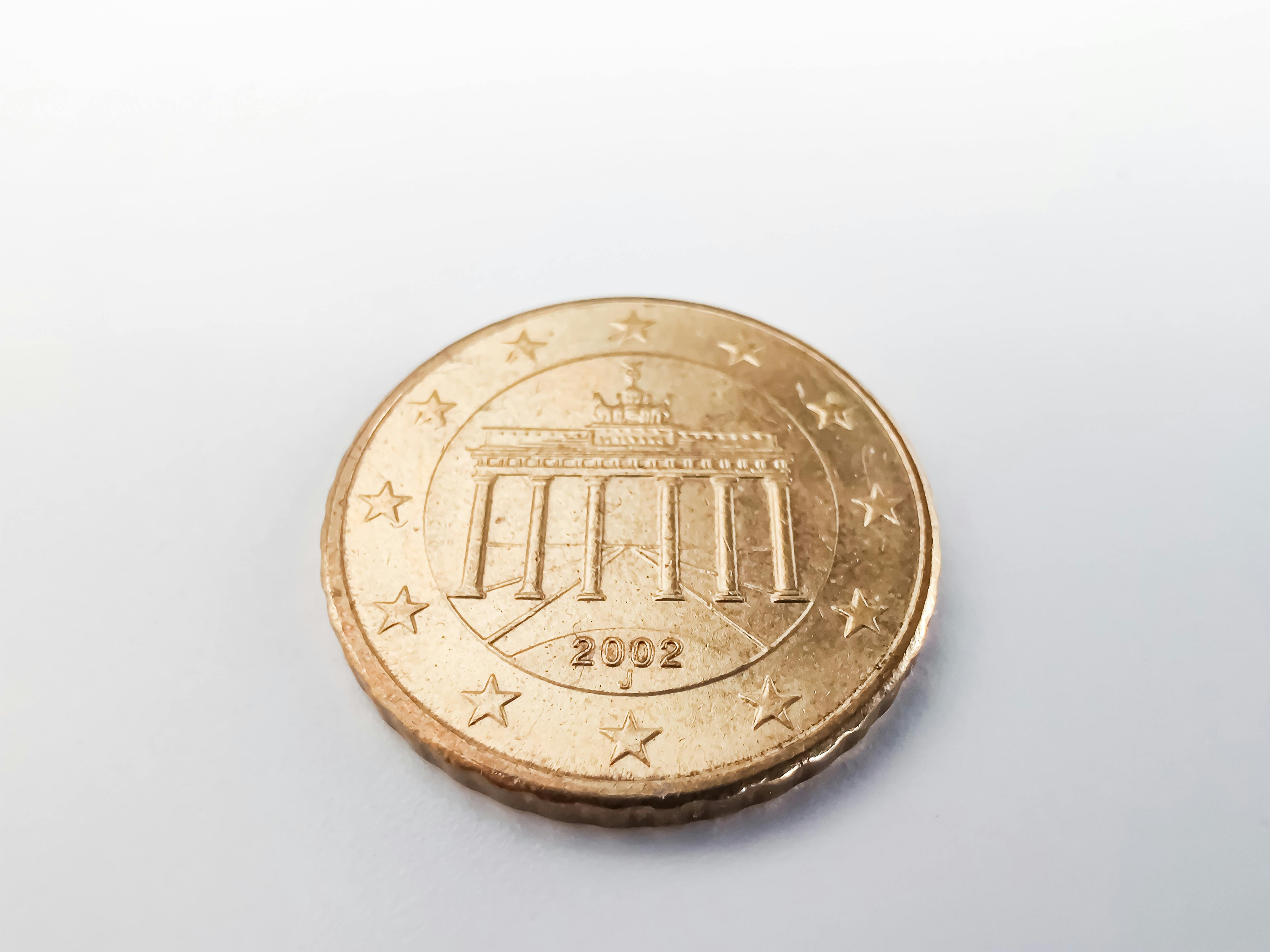 close up view of round gold coin on white surface