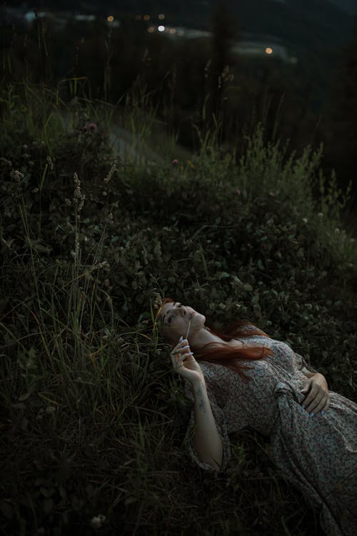 Woman in Floral Dress Lying Down on Green Grass