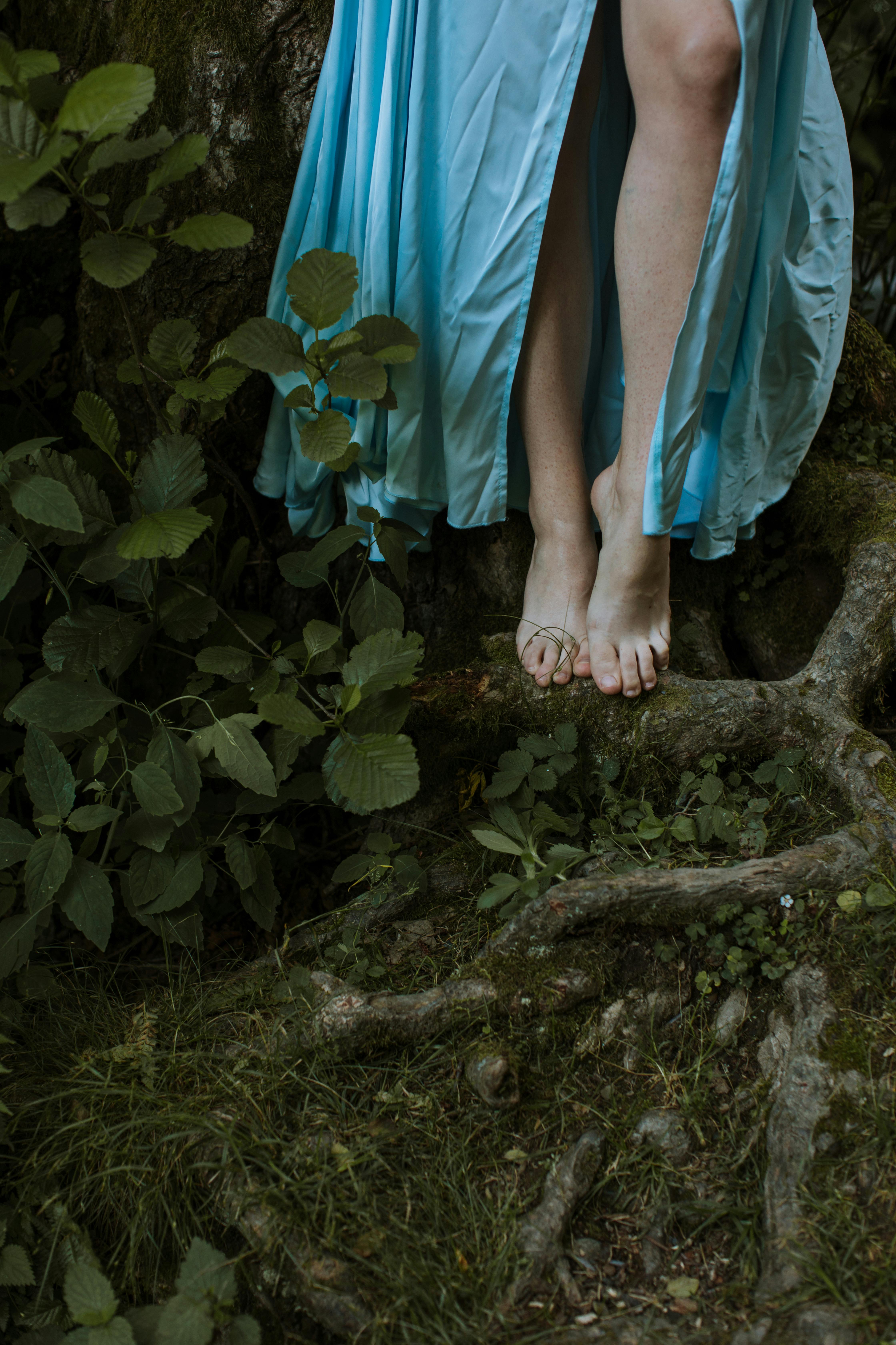 photo of a person s legs beside green leaves