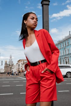 Confident woman in red suits poses in front of St. Petersburg cityscape.