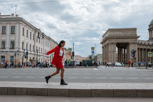 Free Woman in Red Jacket and Black Pants Running on Street Stock Photo
