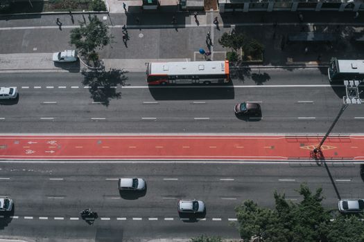 Aerial perspective of city traffic showcasing cars, buses, and bike lanes on a major roadway.