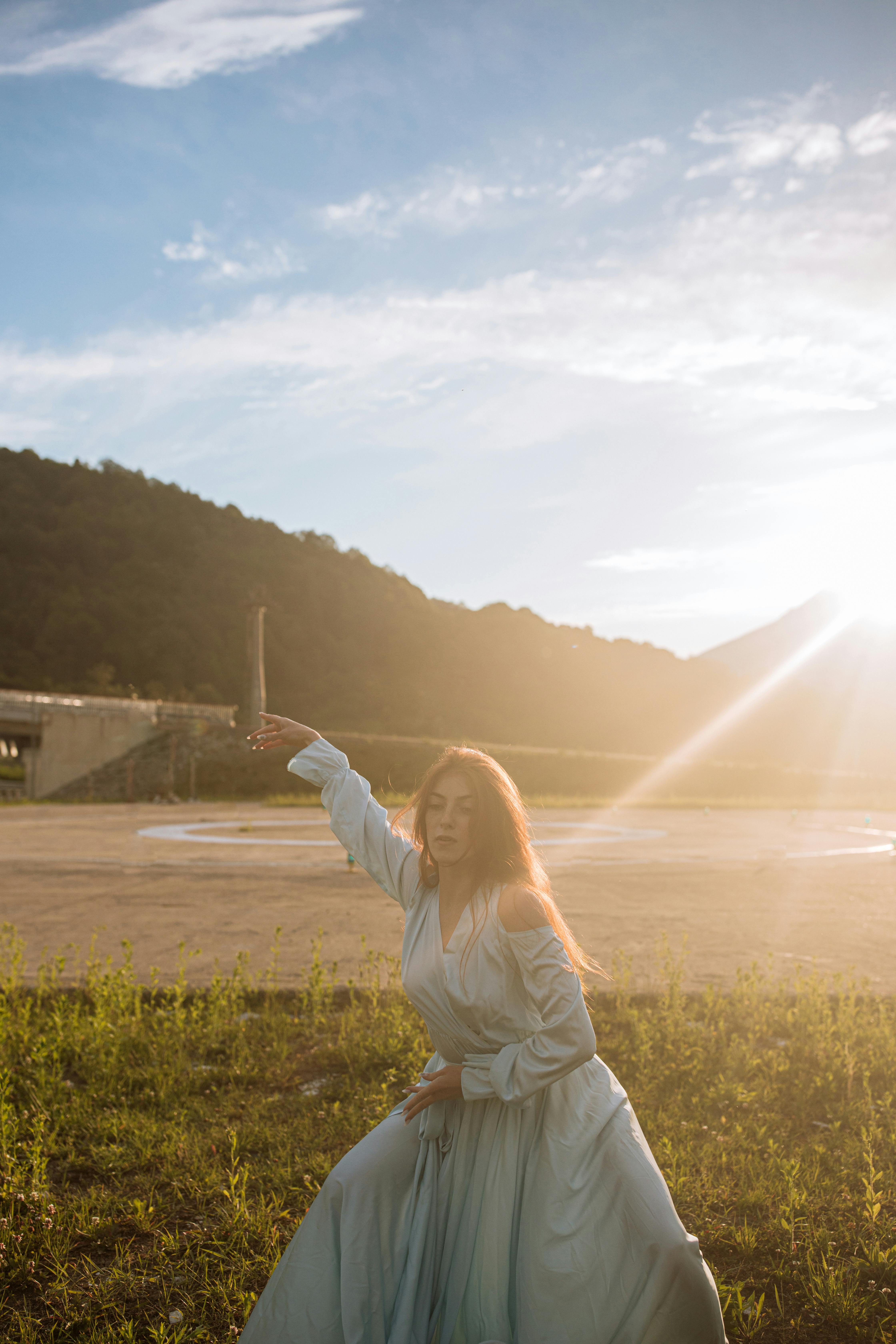 一个女人在阳光直射的田野里优雅地跳舞
