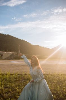 一个女人在阳光直射的田野里优雅地跳舞