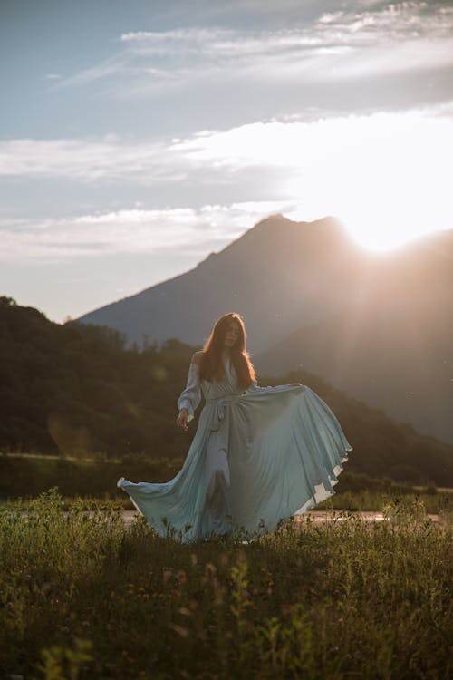 Photo of a Woman Touching Her Dress During Daytime