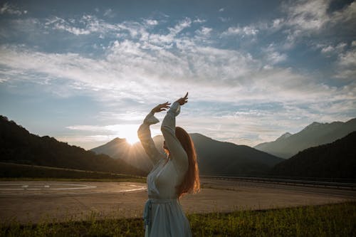 Photo of a Woman Dancing with Her Arms Raised