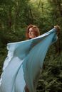 Photo of a Woman Twirling while Holding Her Dress