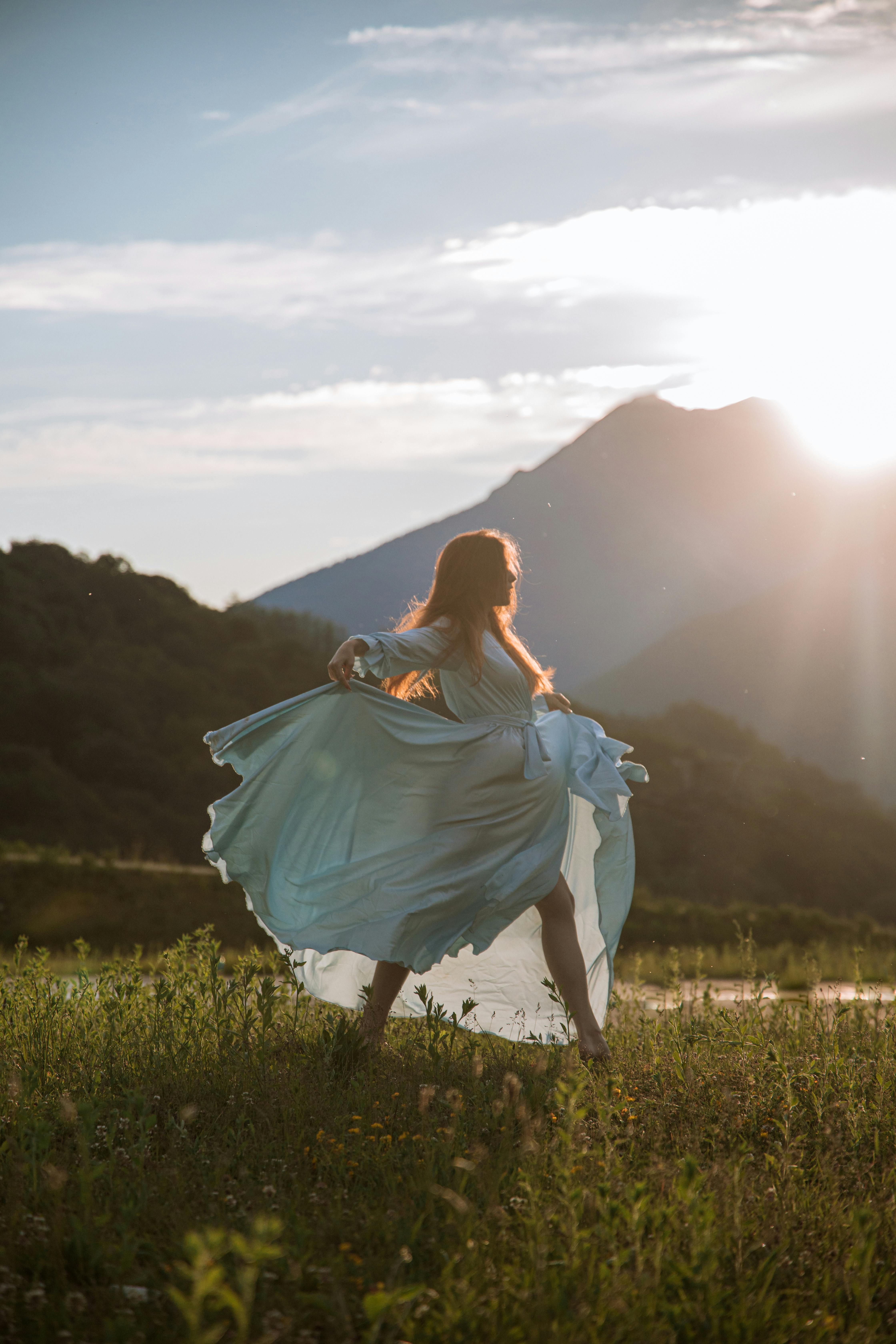 woman in blue dress standing on green grass field