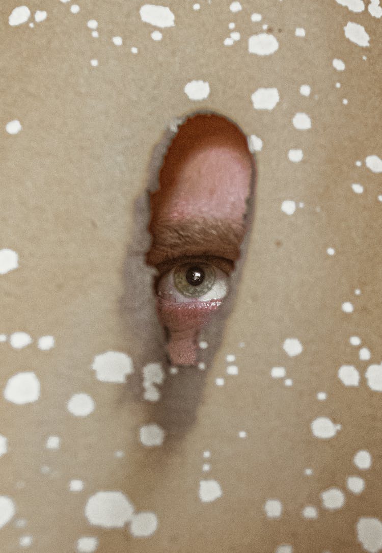 Eye Looking Through Brown Plastic Foam Hole