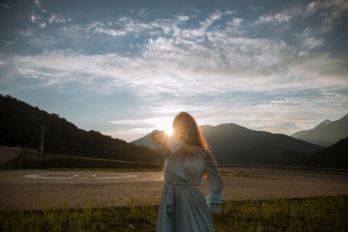 Woman in Blue Dress Under Cloudy Sky