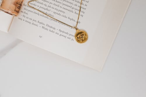 Free Gold Necklace with Pendant on a Book Page Stock Photo