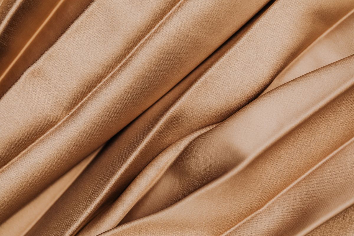 Close detail of pleated cloth in a warm neutral tone