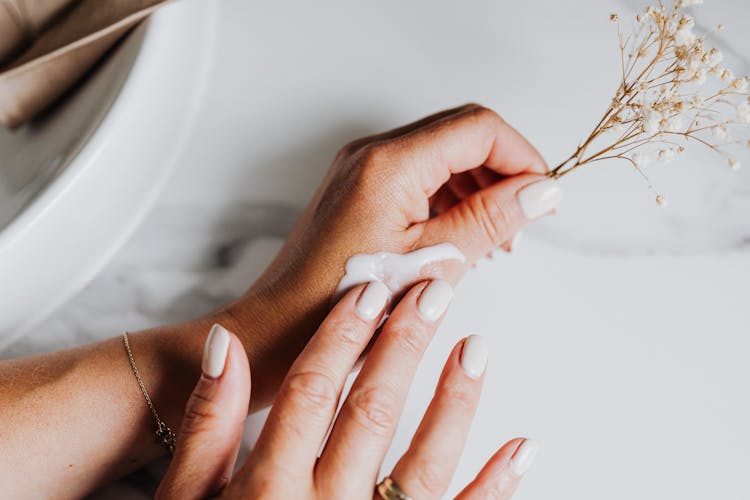 Person Applying Lotion On Hand