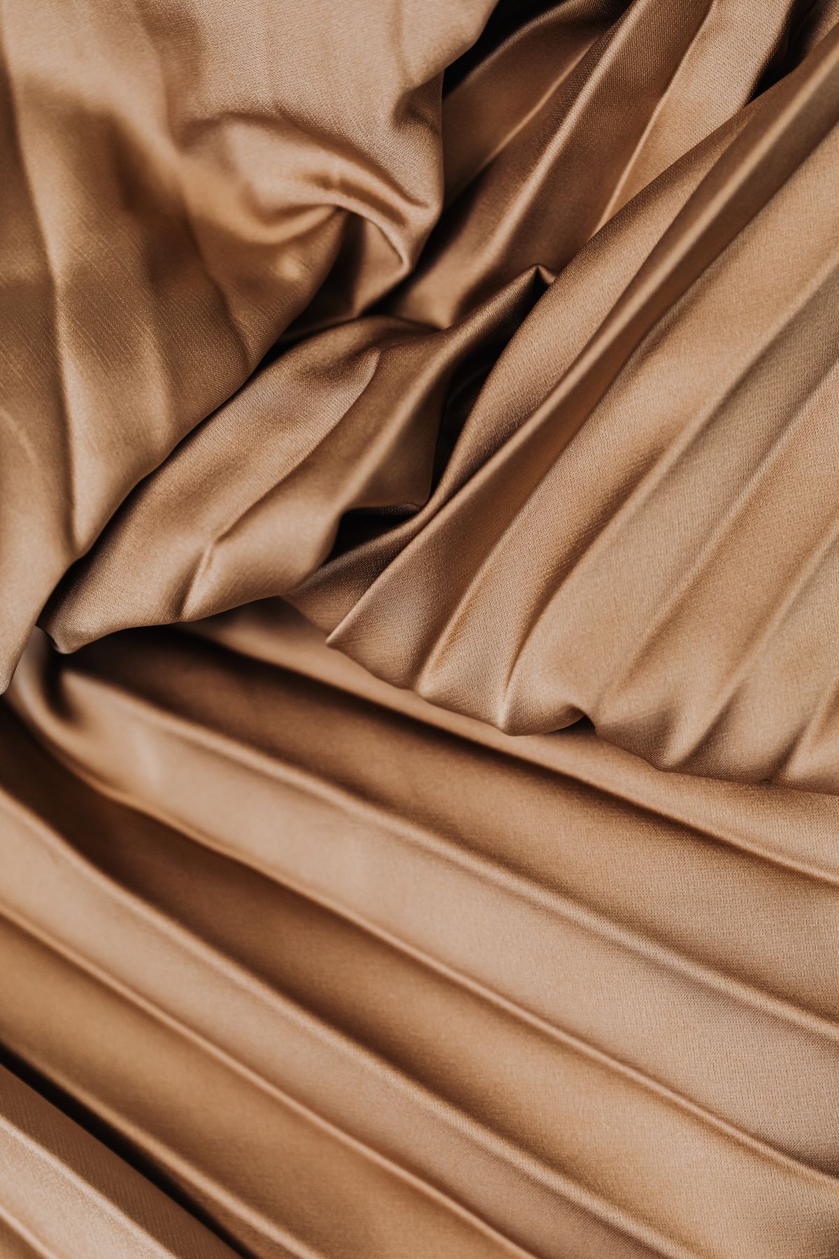 Pleated detail of the Sable cashmere wrap in warm light