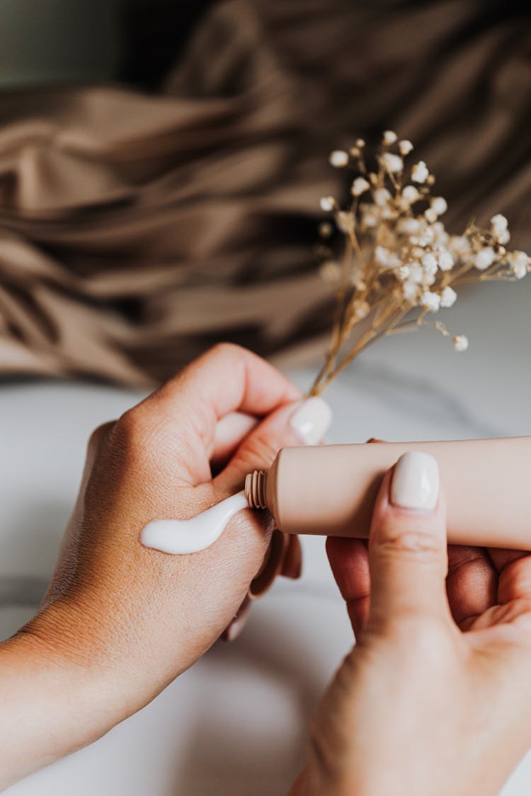 Woman Putting Cream On Hand