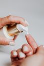 一名妇女用泵瓶涂抹护肤乳液，展示了她修剪整齐的指甲