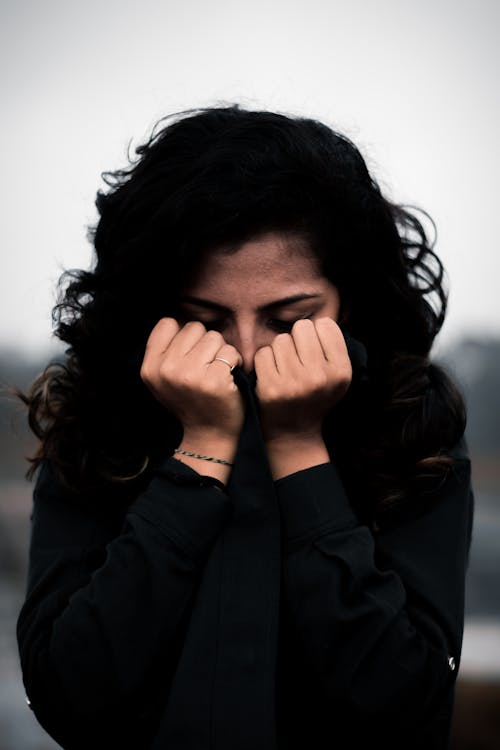 Woman Covering Face in Hands
