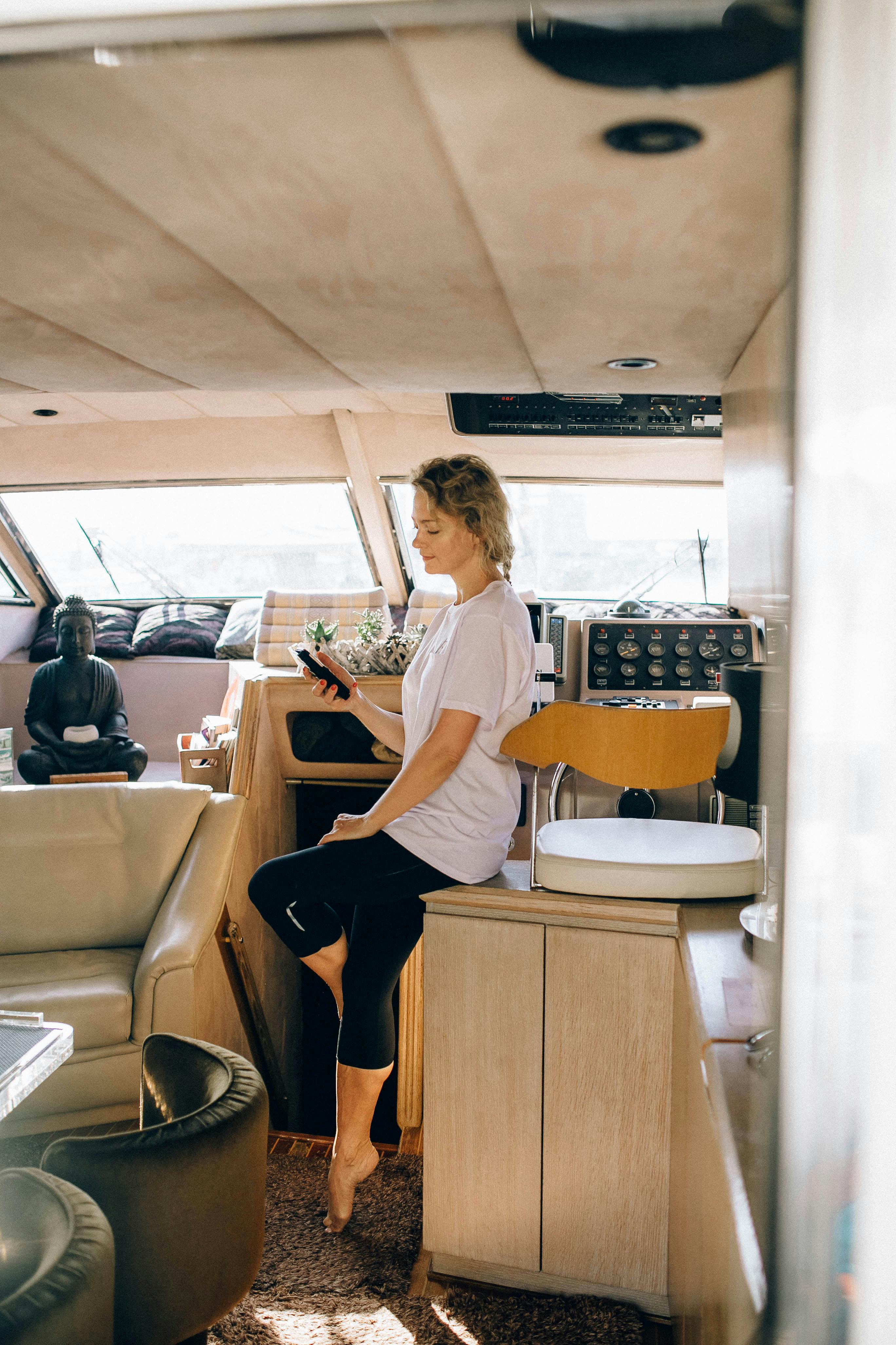 一位穿着休闲装的女人在游艇里用智能手机享受休闲时光