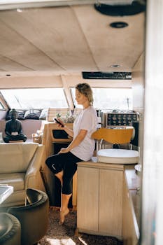 一位穿着休闲装的女人在游艇里用智能手机享受休闲时光