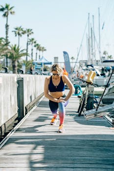 Active woman stretching on a sunny marina walkway surrounded by yachts and palm trees.